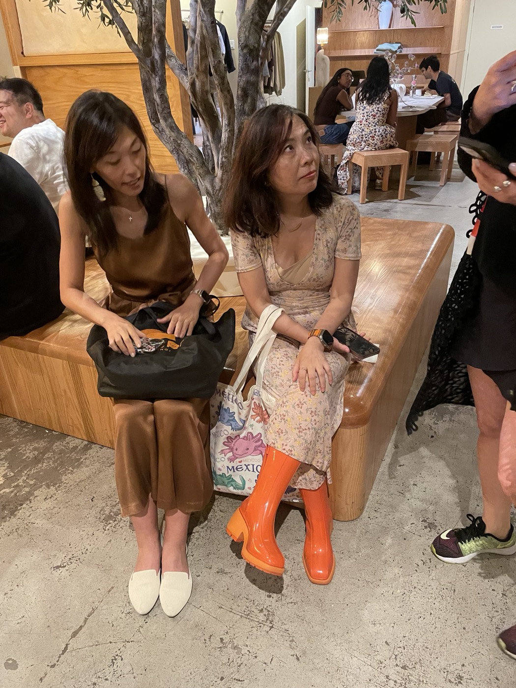 Two attendees connecting on the bench at Manjul Coffee & Clothing